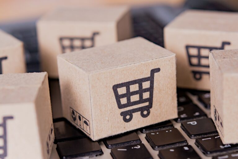 Cardboard box with a shopping cart logo on laptop keyboard.