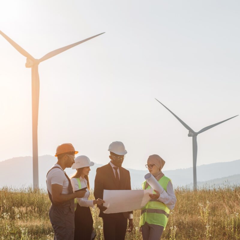 International team examining blueprints of wind turbines