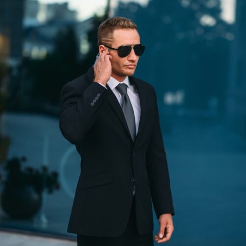 Male bodyguard uses security earpiece outdoors