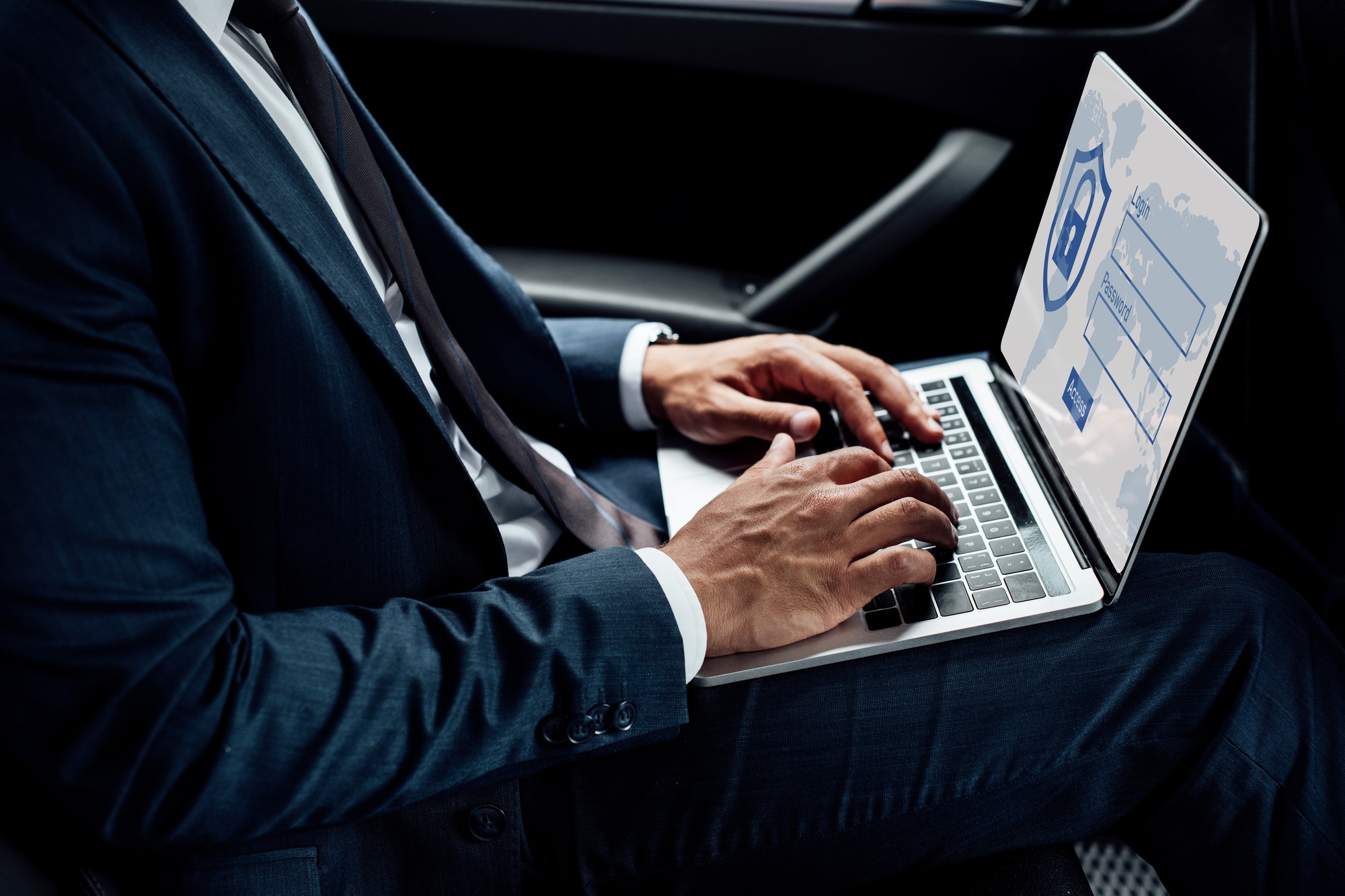 vista parziale di imprenditore afroamericano che usa un laptop con illustrazione di sicurezza Internet in auto