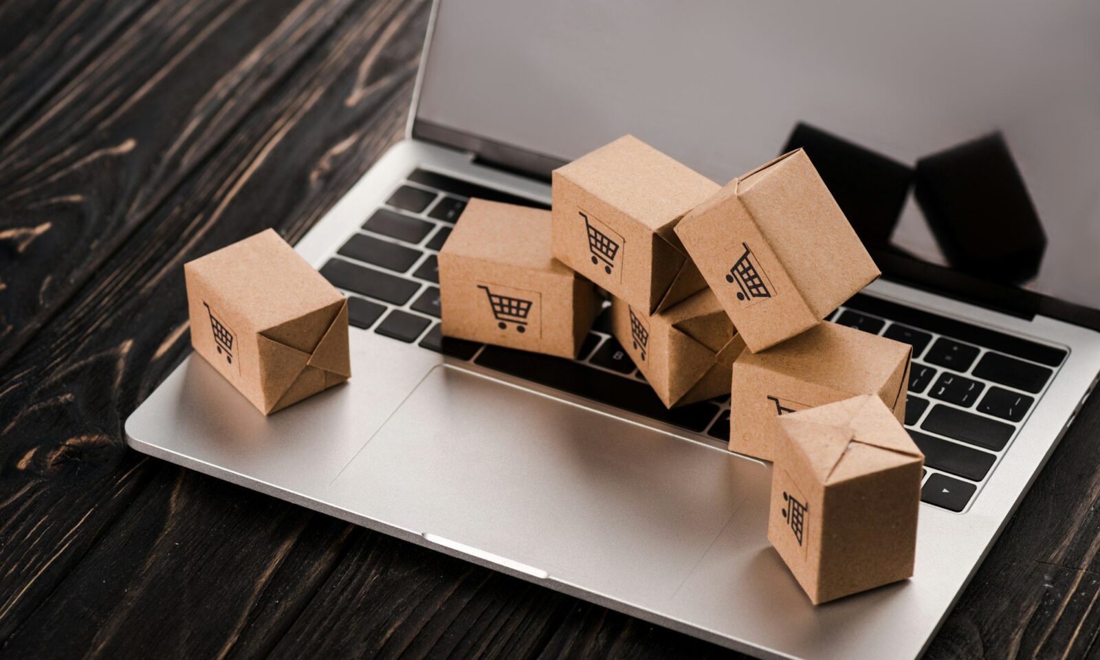 petites-boîtes-en-carton-sur-ordinateur-portable-avec-écran-vide-concept-e-commerce