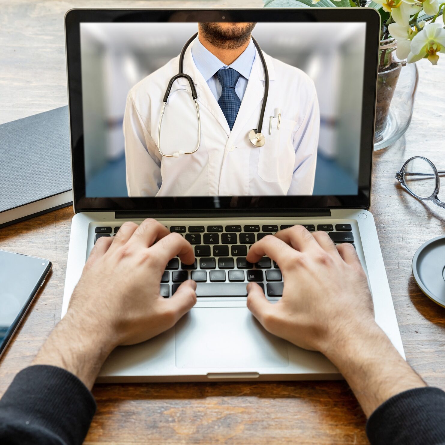 Concetto di telemedicina. Medico di base sullo schermo di un computer, sfondo con scrivania d'ufficio